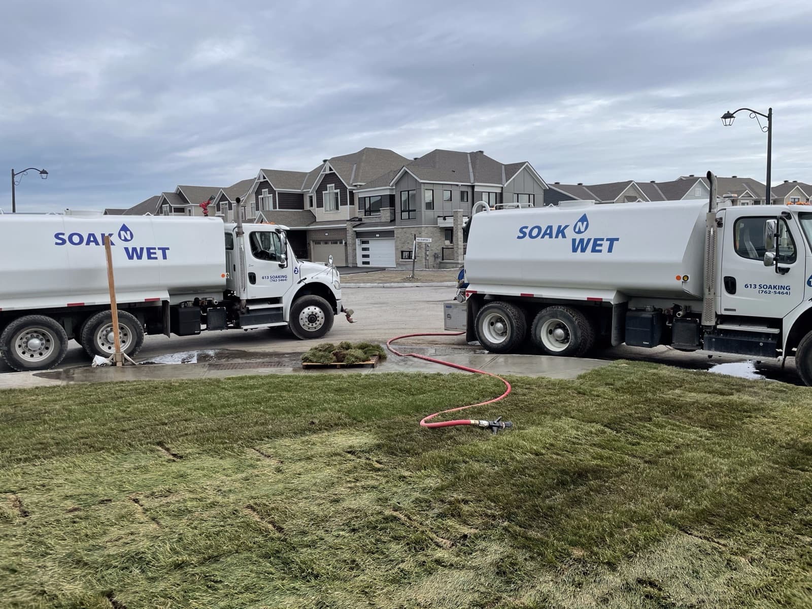 Two Soak N Wet trucks watering fresh sod on a landscaping job